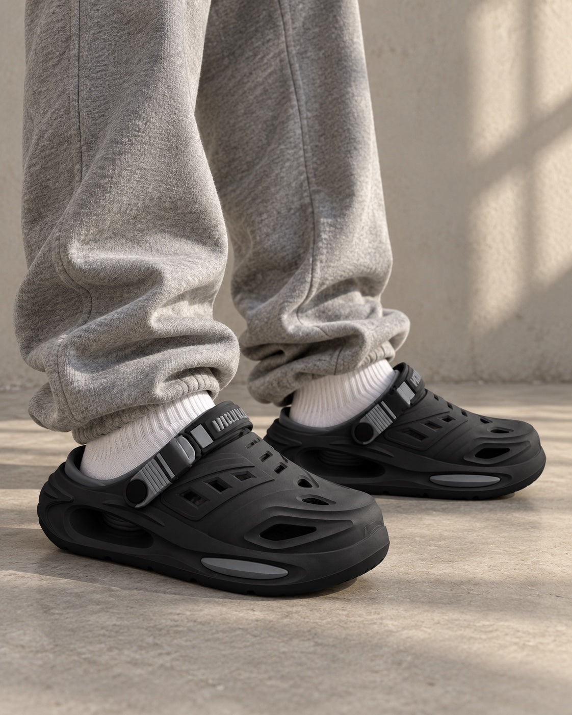 Black Recovery Clogs worn with white socks and baggy grey sweatpants