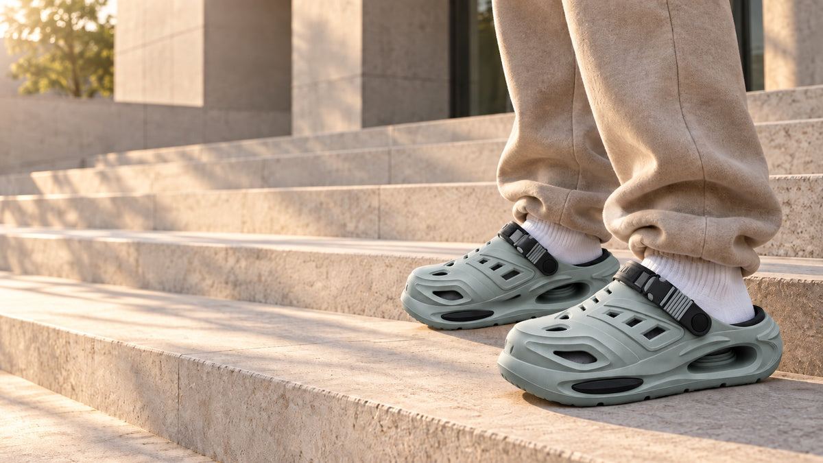 Grey Recovery Clogs worn on stone steps with beige sweatpants
