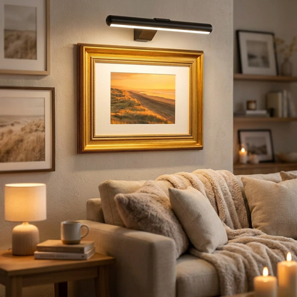 Wireless LED picture light illuminating framed art in living room